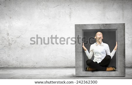 Young woman trapped in stone cube in wall