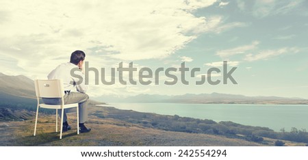 Back view of businessman sitting in chair and thinking