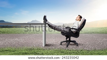 Young businessman sitting relaxed in chair with legs on table