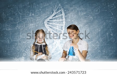 Young teacher and school girl at chemistry lesson