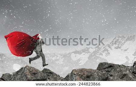 Businessman in Santa hat running with bag on back