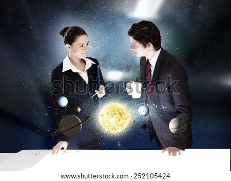 Young businesswoman and businessman and planets of space spinning around