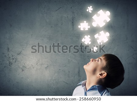 Young boy of school age looking at puzzle elements