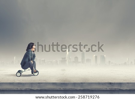 Young pretty businesswoman riding three wheeled bike
