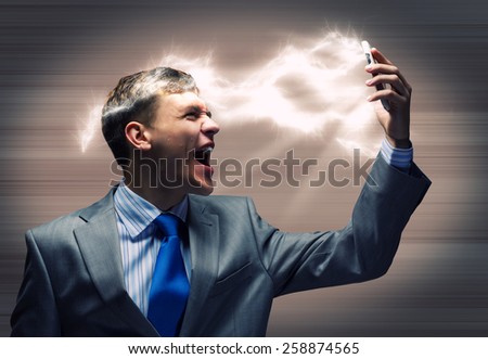 Angry businessman screaming furiously in mobile phone