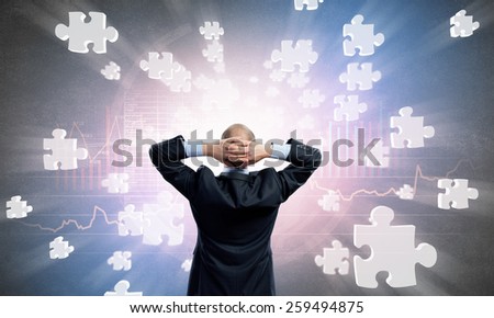 Rear view of businessman with arms on head thinking something over