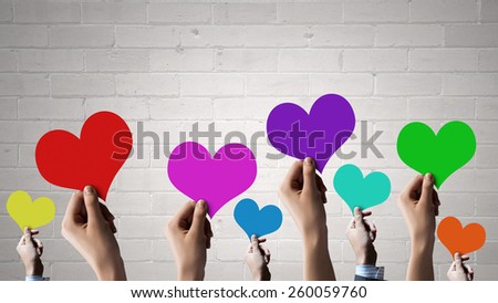 Close of many human hands with colorful cards