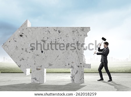 Young businessman with hammer in hands and cement banner