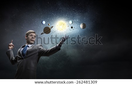 Young businessman and planets of space spinning around