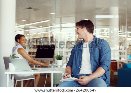 Shot of two collegues having a friendly conversation at the desk
