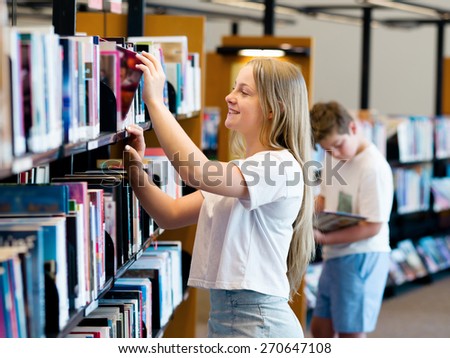 teenage girl in library choosing books