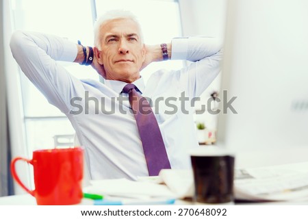 Businessman in office relaxing leaning back on chair