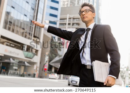 Businessman trying to catch a taxi in business cuty district