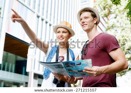 Happy young couple as tourists with a map