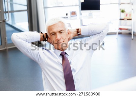 Businessman in office relaxing leaning back on chair