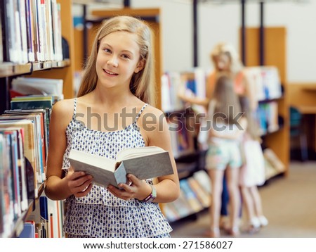 Teenage girl picking a book in public library