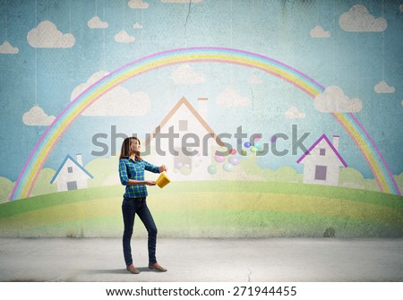 Young woman in casual holding yellow bucket with splashes