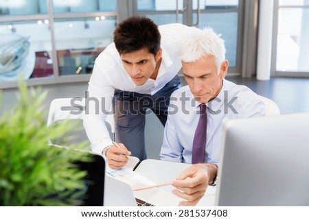 Two businessmen in fornt of computer in office