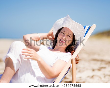 Woman in white clothes on the beach on sunny day