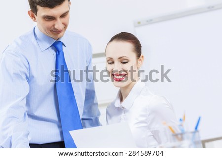 Businessman and businesswoman in office sitting at table and having conversation