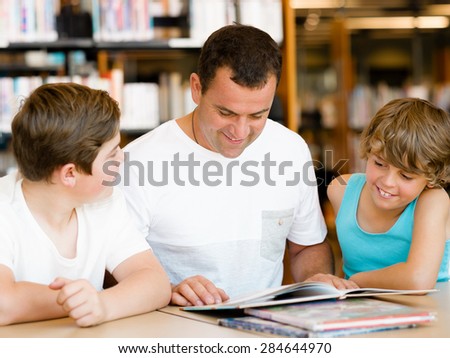 Father with sons in library with books