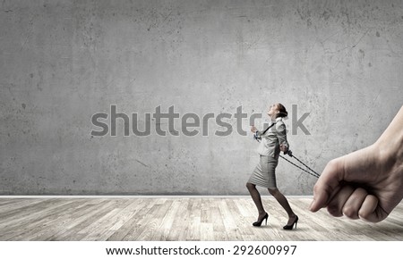 Young businesswoman with ropes on hands trying to escape