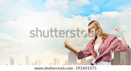 Young funny girl with opened book in hands