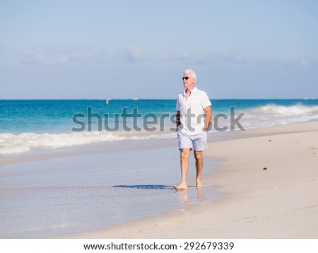 Man in white clothes on the beach on sunny day