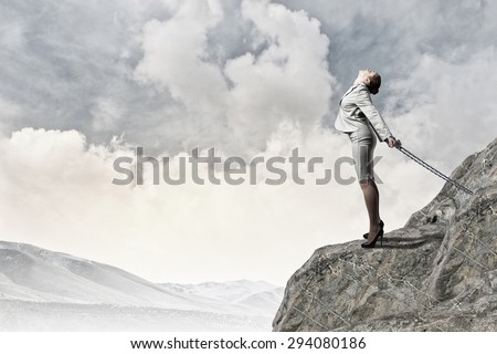 Young businesswoman with ropes on hands trying to fly