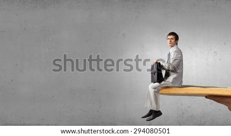 Businessman in white suit sitting on opened book