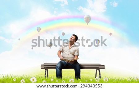 Fat man sitting on bench with book and looking away