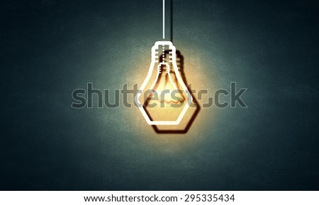 Illuminating hanging light bulb on dark background