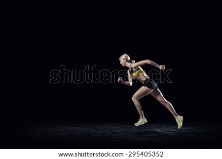 Running woman in sport wear on black background