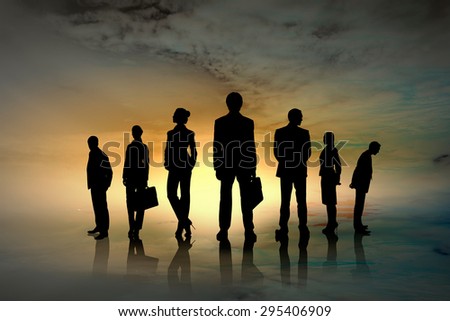 Silhouettes of group of business people standing in line on sunset background