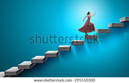 Young woman in evening long dress walking up the staircase