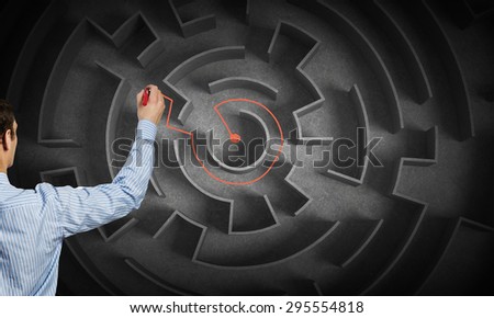 Close up of businessman drawing way out of labyrinth