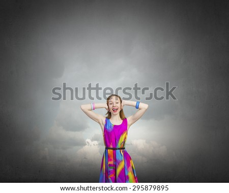 Young woman closing her ears with palms and enjoying the silence