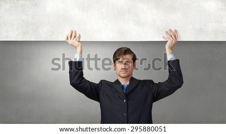 Young handsome businessman holding white blank banner above head