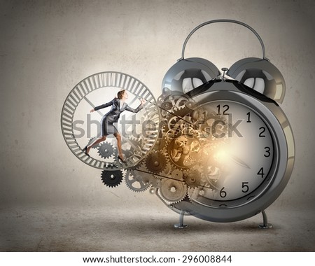 Young businesswoman running in wheel of gears mechanism