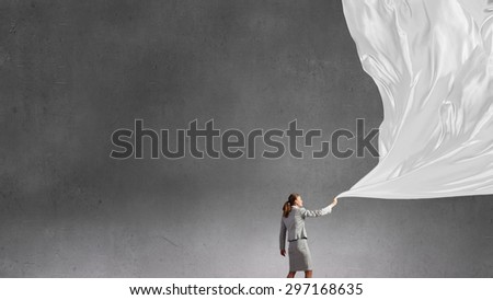 Young pretty businesswoman pulling clothing blank banner
