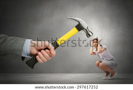 Close up of hammer in male hand attacking scared woman