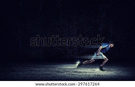 Running man in blue sport wear on black background