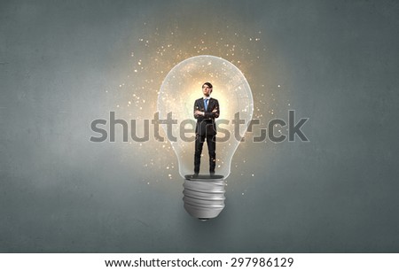 Man in business suite stay inside light bulb