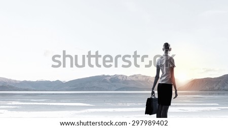 Rear view of businesswoman look at sunrise above mountain