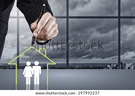 Close up of human hand drawing happy family and real estate concept