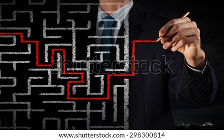 Close up of businessman drawing way out of labyrinth