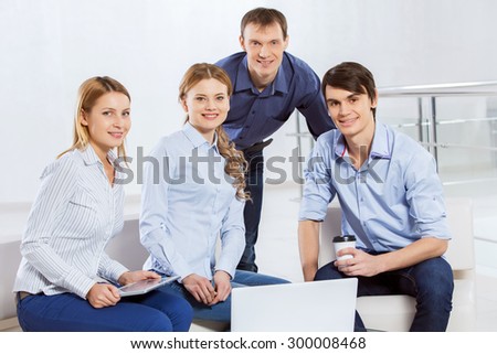 Four co-workers discussing business ideas in office