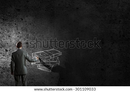 Back view of businessman drawing money banknotes on wall