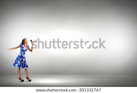Young woman making some announcement in trumpet