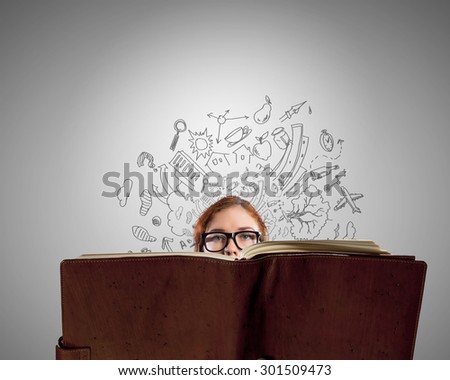 Young woman in glasses with opened book in hands